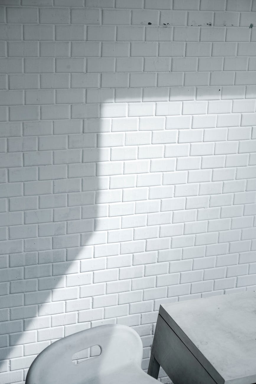 white brick wall near white chair
