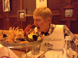 The lobster guy eats lobster at a restaurant.