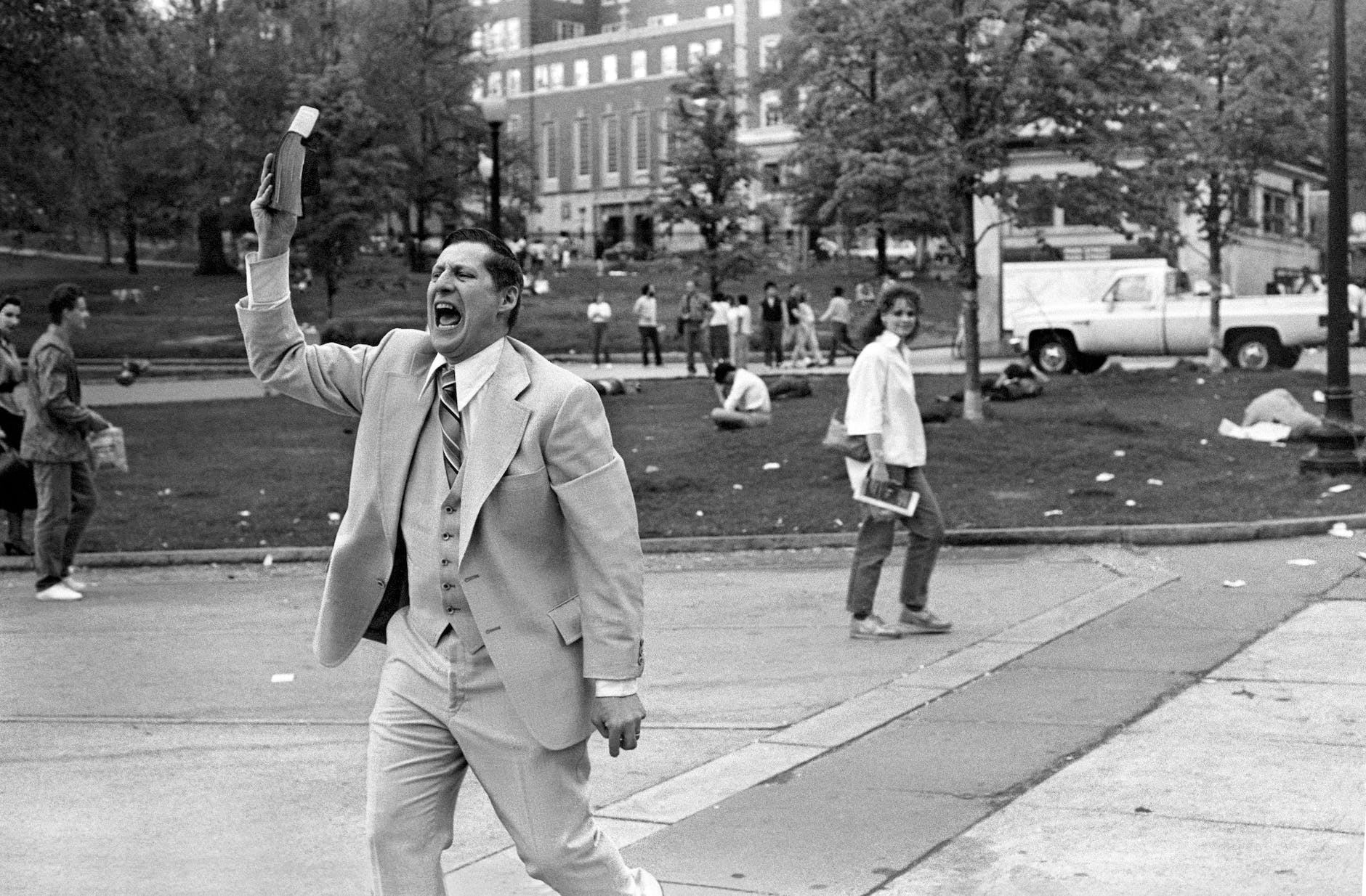 man in white suit standing on street