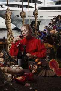 Woman wearing a red blouse holding a cup of red wine. The Lobster Guy.